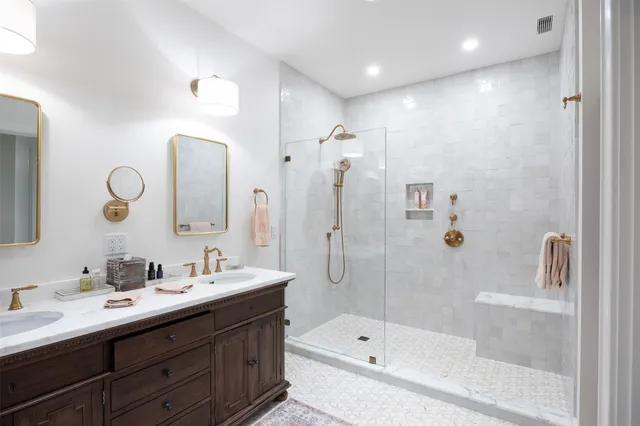 a bathroom with a double vanity sink mirror and bathtub