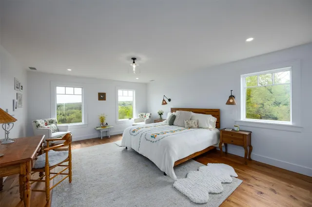 a spacious bedroom with a bed and wooden floor