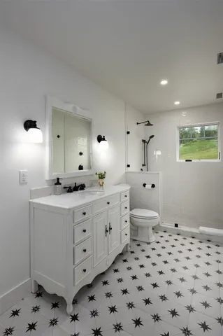 a bathroom with a double vanity sink mirror and toilet