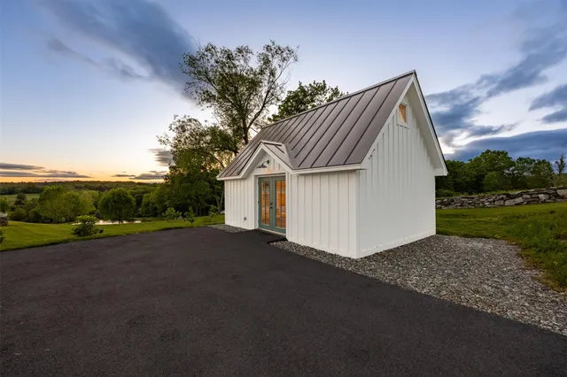 a view of a house with backyard and trees