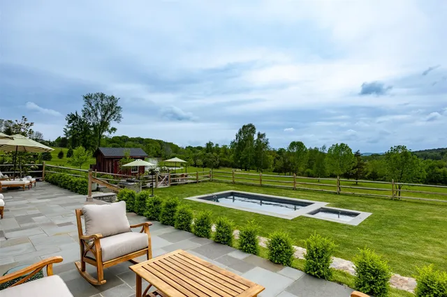 an aerial view of a house having patio with a table and chairs