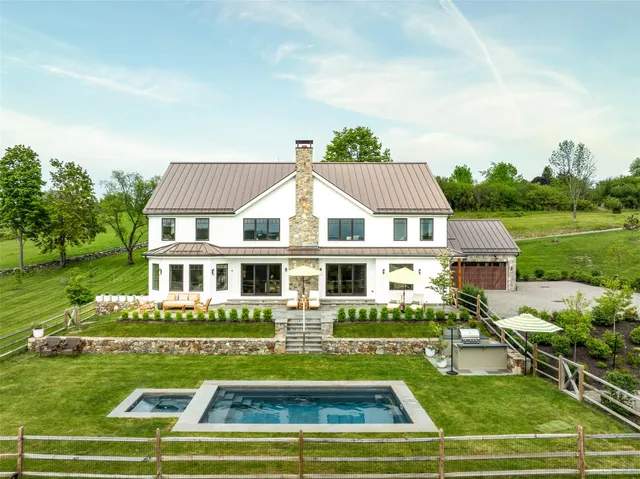 a view of a house with a big yard and potted plants