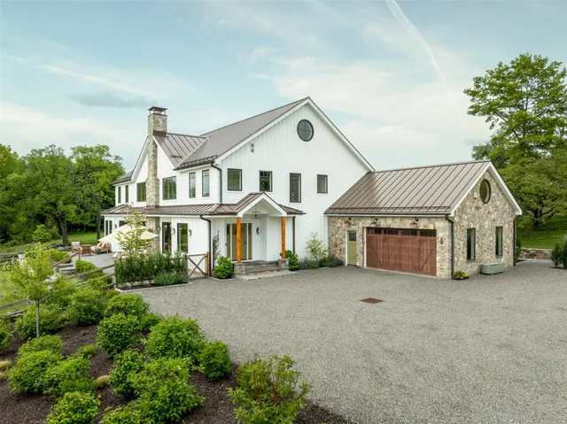 a front view of a house with a garden and plants