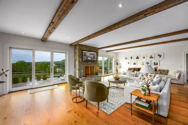 a living room with fireplace furniture and a large window