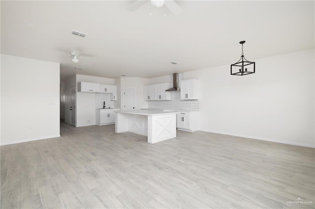 2015 Cassandra Street Mission, TX 78572 - Photo 4 of 15 a big room with chandelier and kitchen view