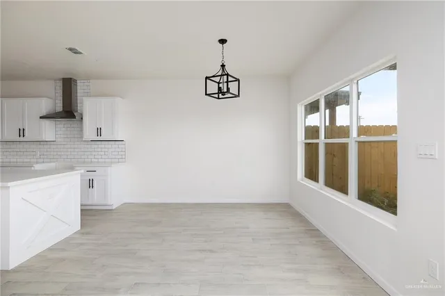 a view of a kitchen with an empty space and a window