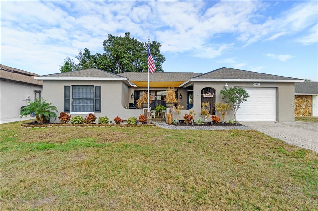9413 Barnstead Lane Port Richey, FL 34668 - Photo 1 of 1 a front view of house with yard and trees around
