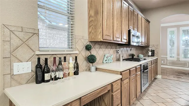 a kitchen with stainless steel appliances granite countertop a sink a stove and a refrigerator