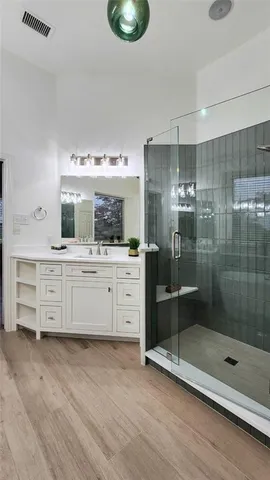 a bathroom with a double vanity sink mirror and shower
