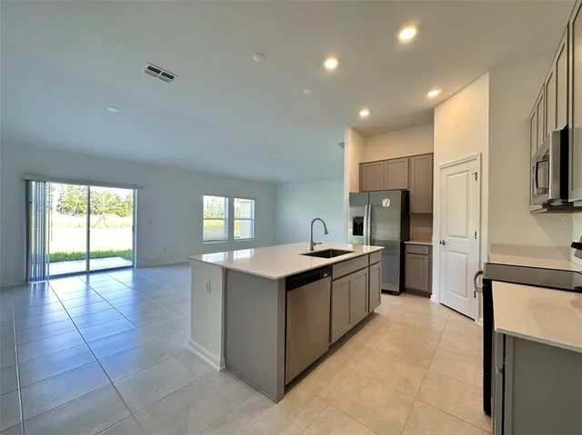 a kitchen with stainless steel appliances a sink stove and cabinets