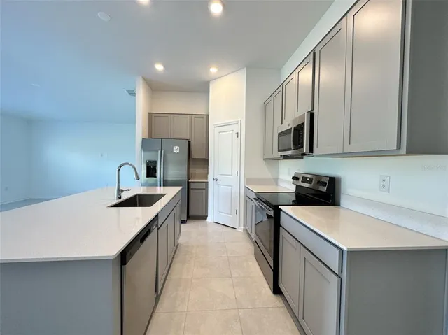 a view of empty room with a kitchen