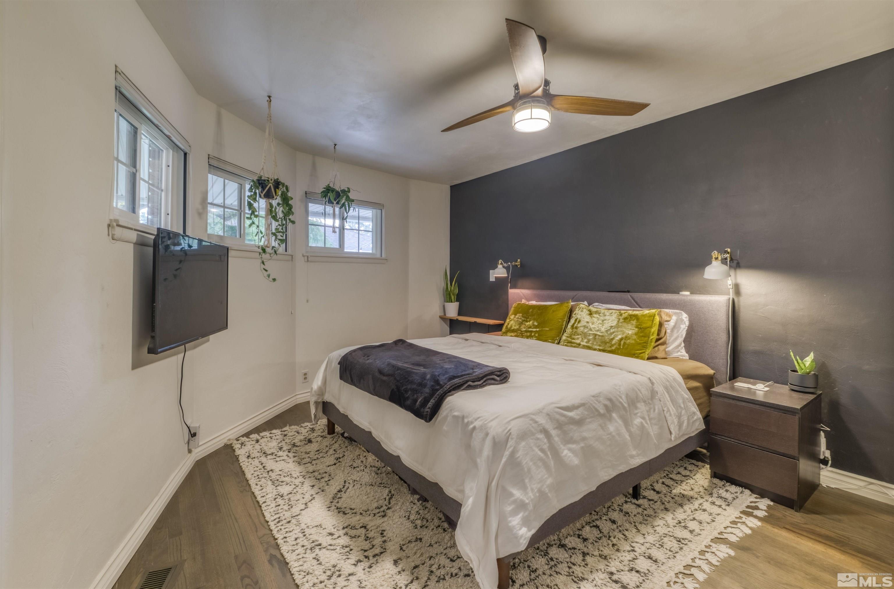 1795 Hunter Lake Drive Reno, NV 89509 - Photo 12 of 32 a bedroom with a bed a lamp and a flat screen tv