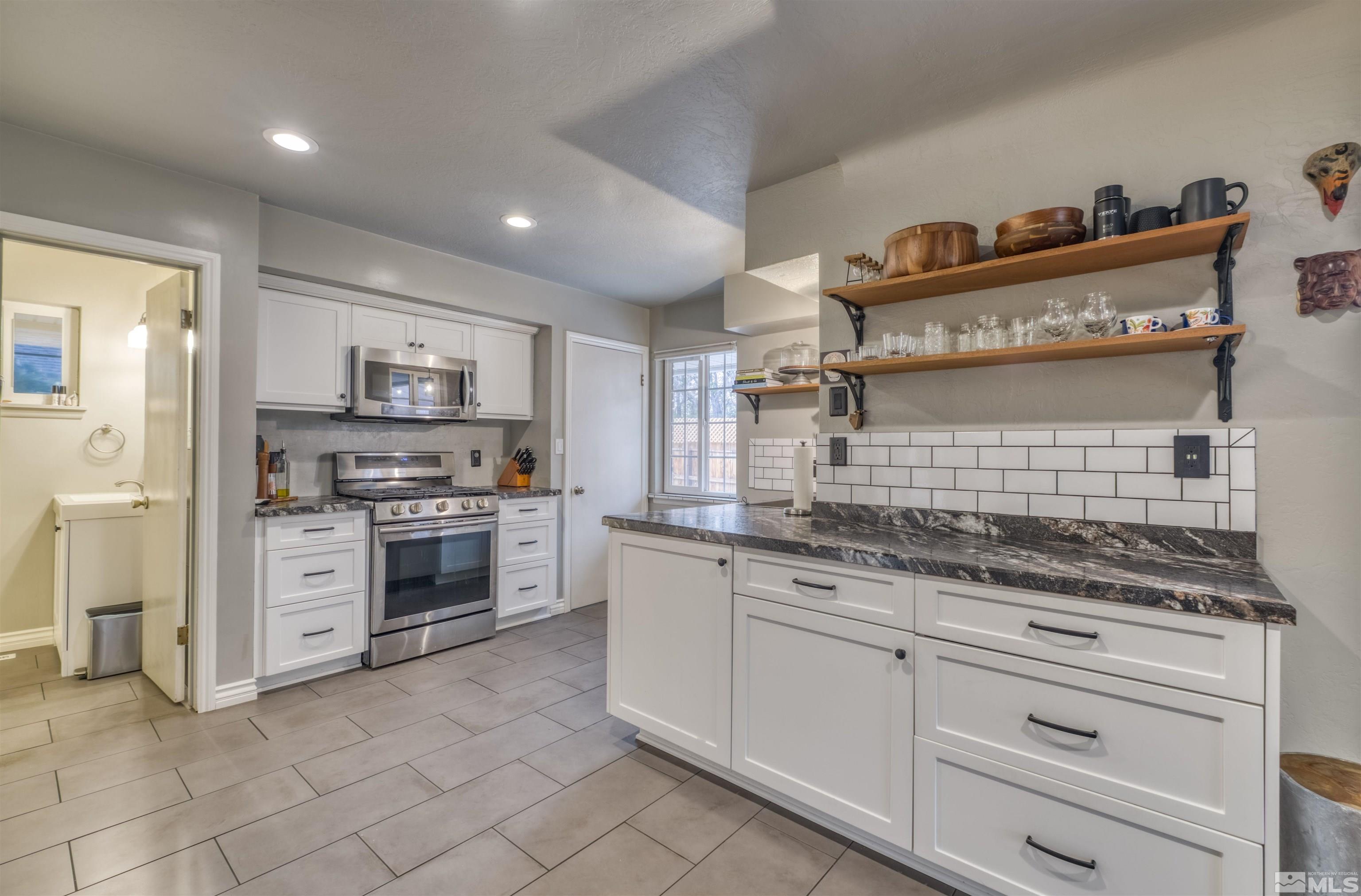 1795 Hunter Lake Drive Reno, NV 89509 - Photo 10 of 32 a kitchen with granite countertop white cabinets and white appliances