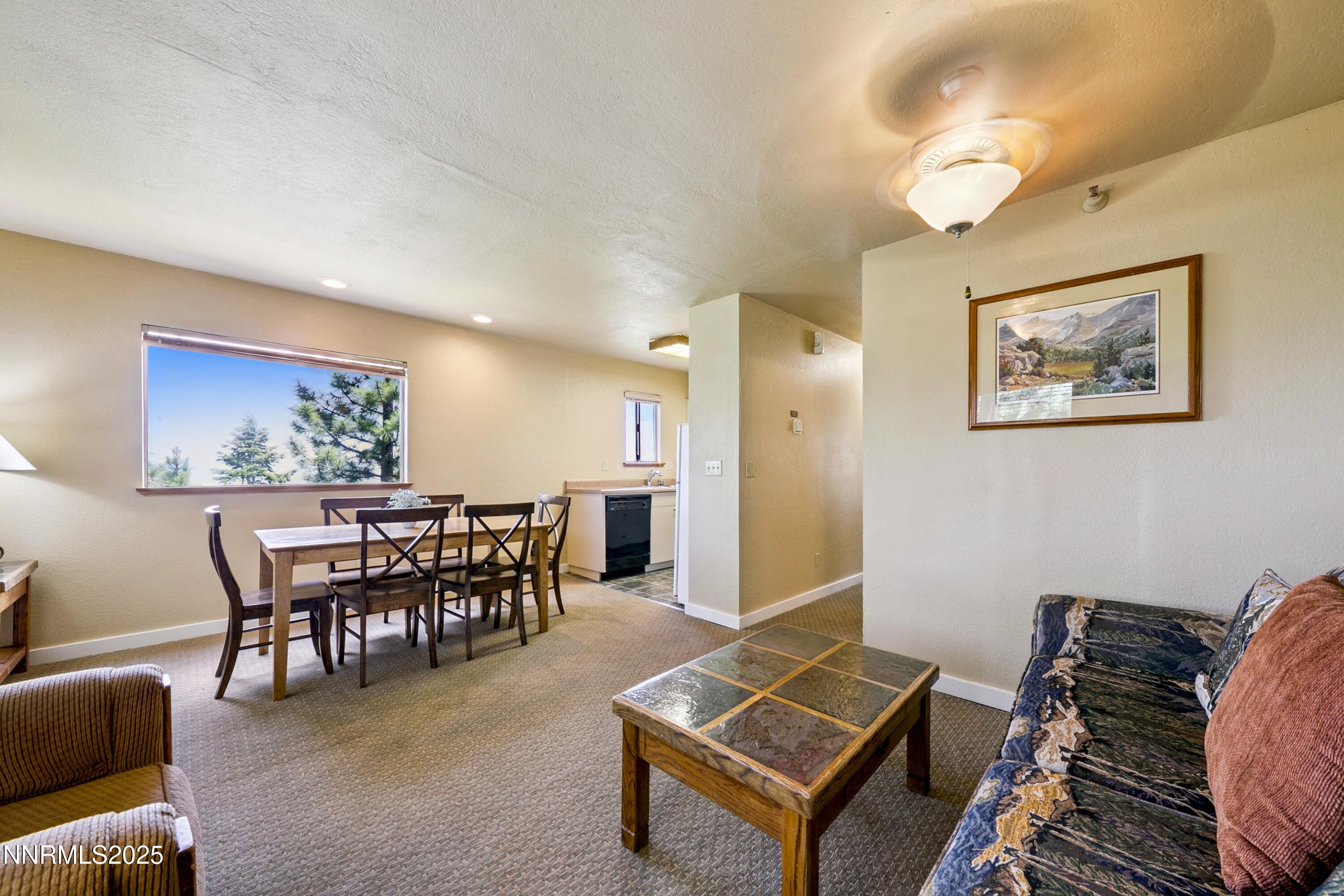305 Galaxy Lane, Unit 3 Stateline, NV 89449 - Photo 3 of 49 a living room with furniture a dining table and paintings on the wall