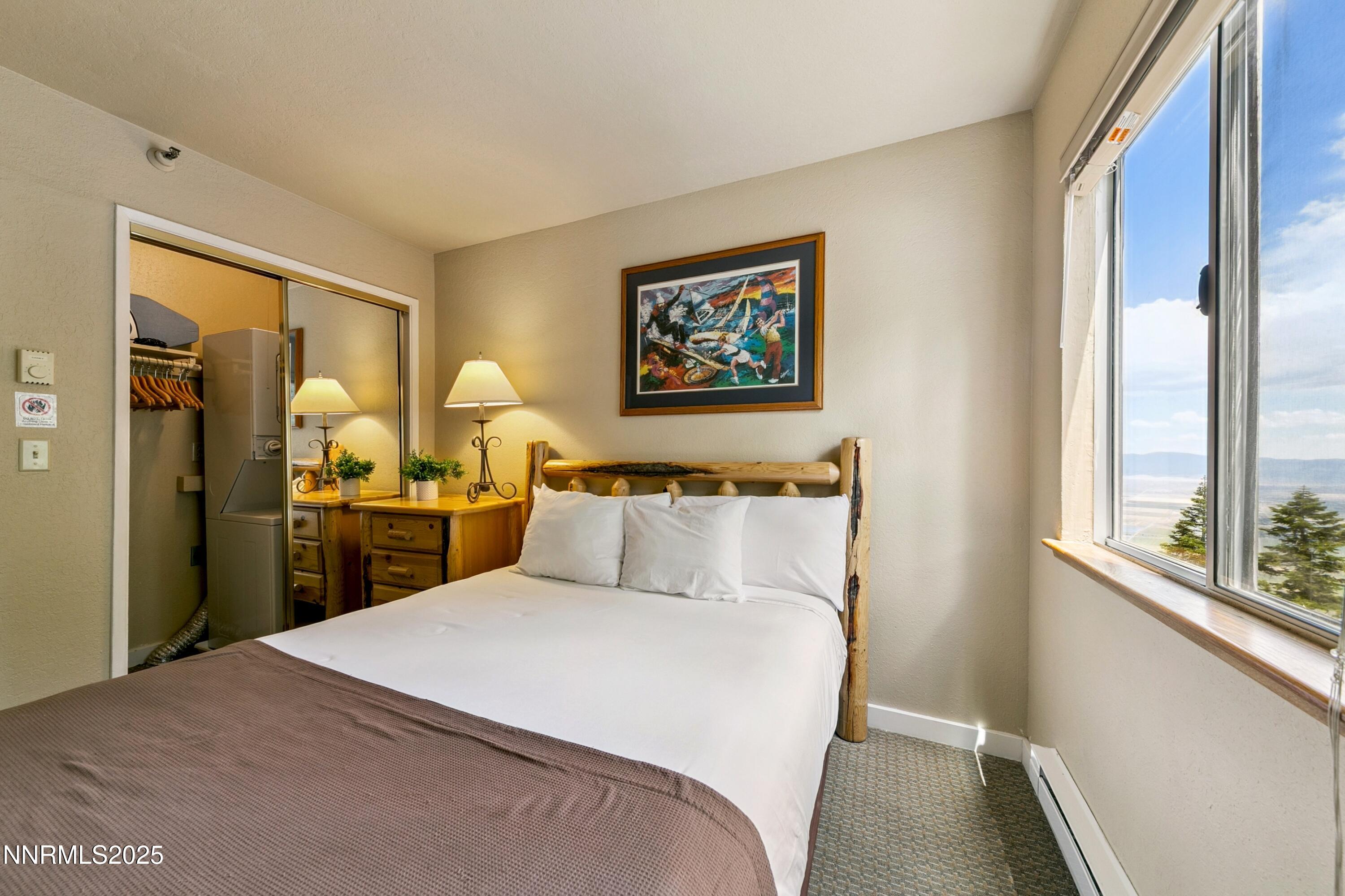 305 Galaxy Lane, Unit 3 Stateline, NV 89449 - Photo 6 of 49 a bedroom with a large bed and a chandelier