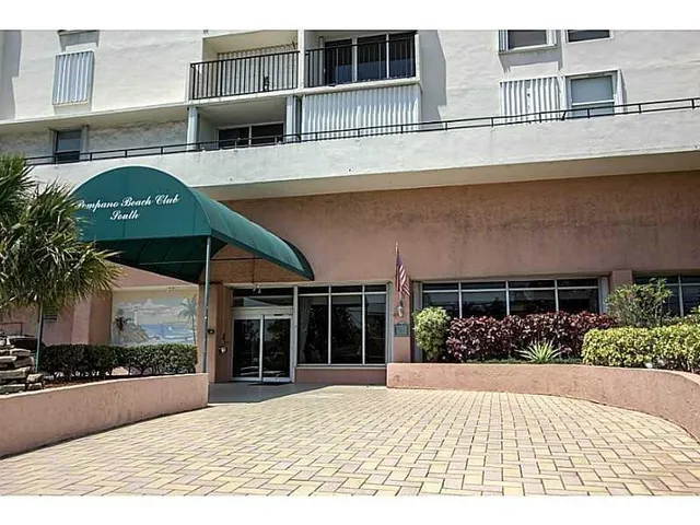 a front view of a building with a garden