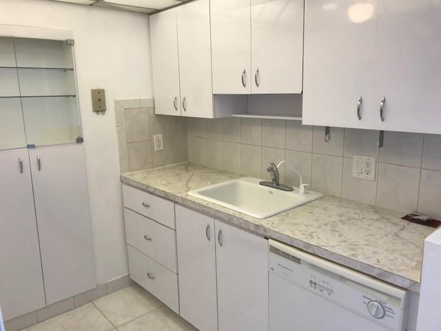 111 Briny Avenue, Unit 806 Pompano Beach, FL 33062 - Photo 5 of 40 a kitchen with granite countertop white cabinets and a sink