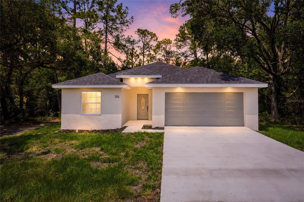 2132 Pine Meadows Golf Course Road Eustis, FL 32726 - Photo 1 of 62 a front view of a house with a yard and garage