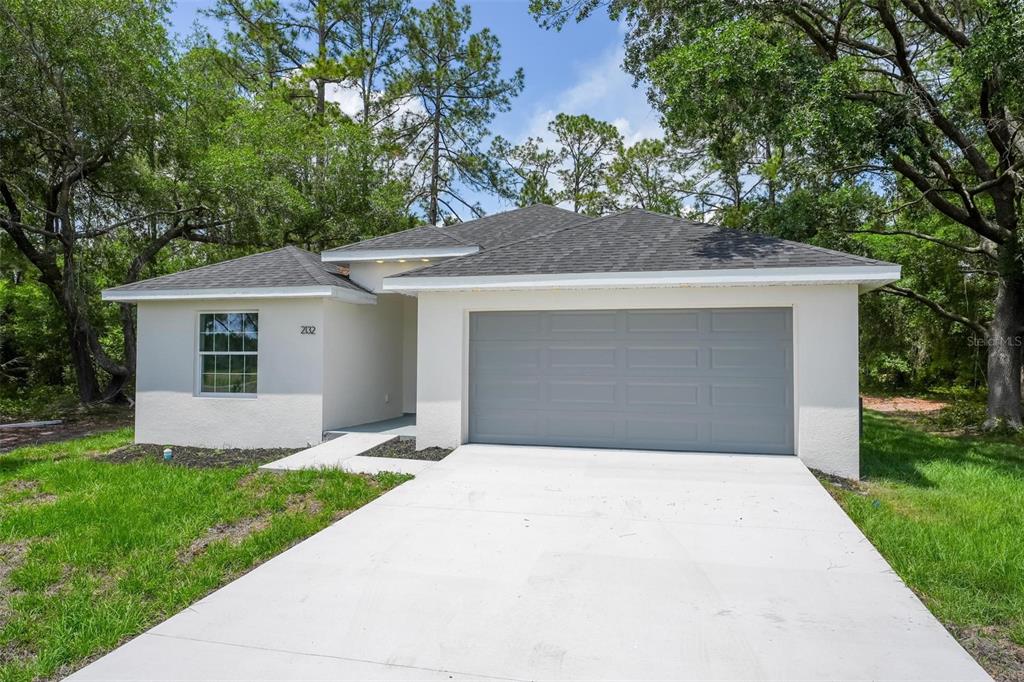 2132 Pine Meadows Golf Course Road Eustis, FL 32726 - Photo 2 of 62 a front view of a house with a yard and garage