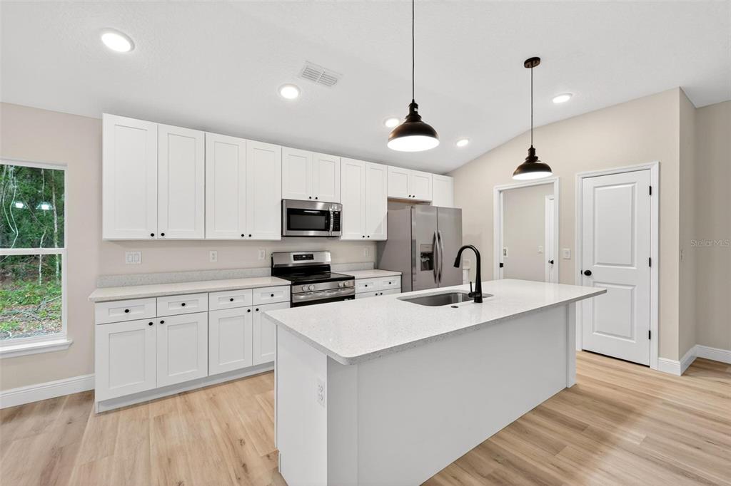 2132 Pine Meadows Golf Course Road Eustis, FL 32726 - Photo 10 of 62 a kitchen with stainless steel appliances granite countertop a sink a stove a refrigerator cabinets and wooden floor