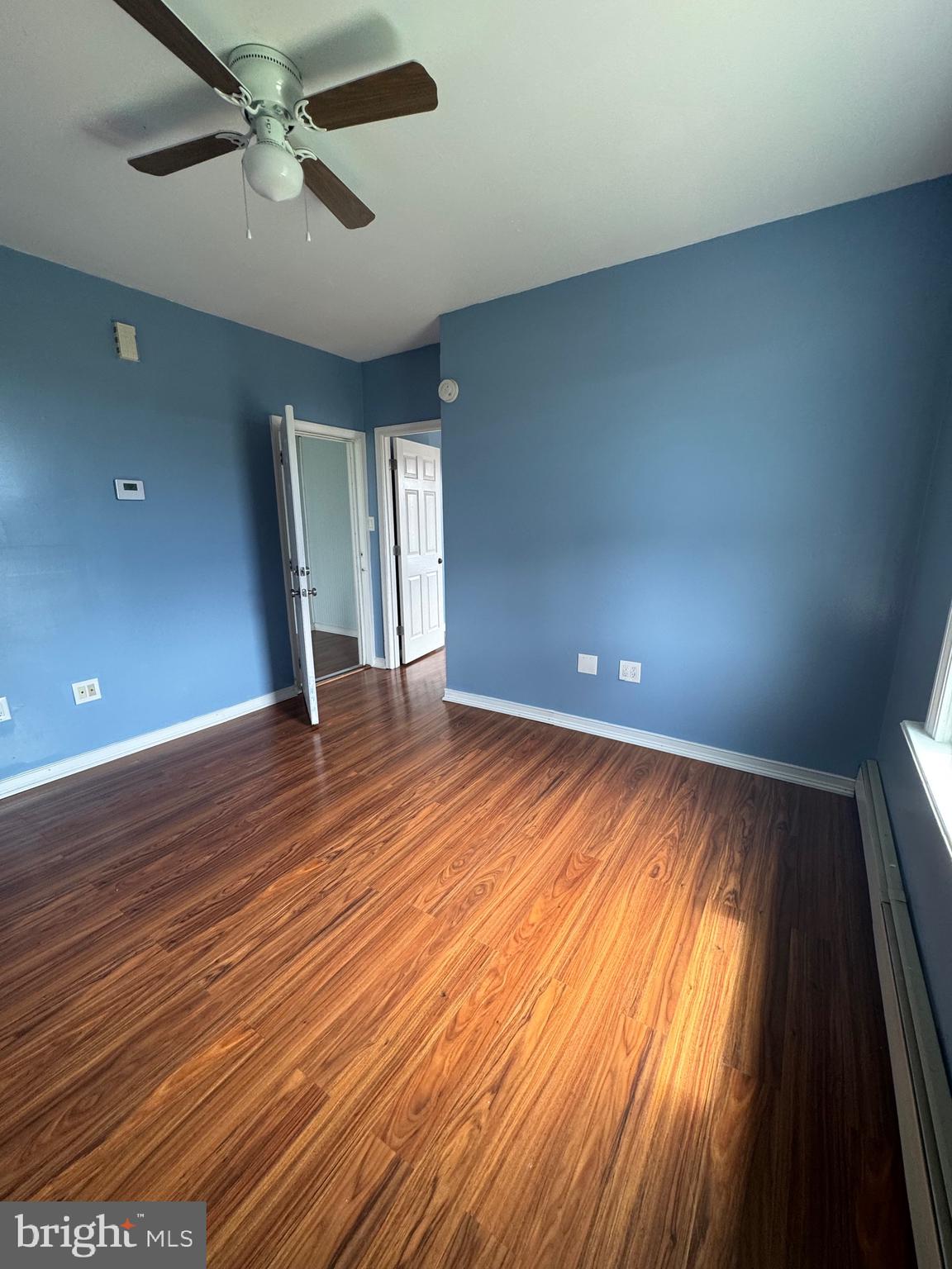 3706 Old York Road, Unit 2 Baltimore, MD 21218 - Photo 5 of 17 wooden floor in an empty room with a window