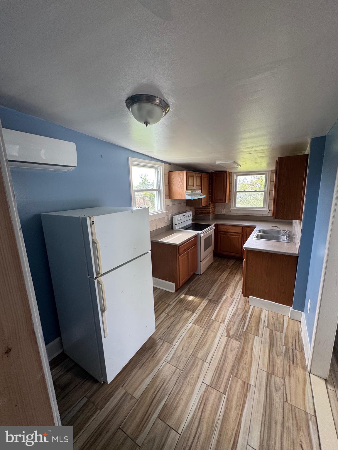 3706 Old York Road, Unit 2 Baltimore, MD 21218 - Photo 7 of 17 a kitchen with a refrigerator a sink dishwasher stove and wooden cabinets