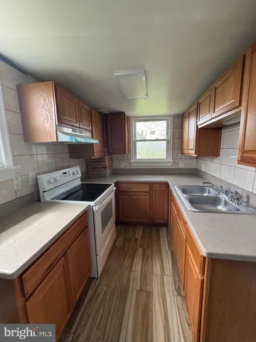 a kitchen with a sink stove top oven and cabinets