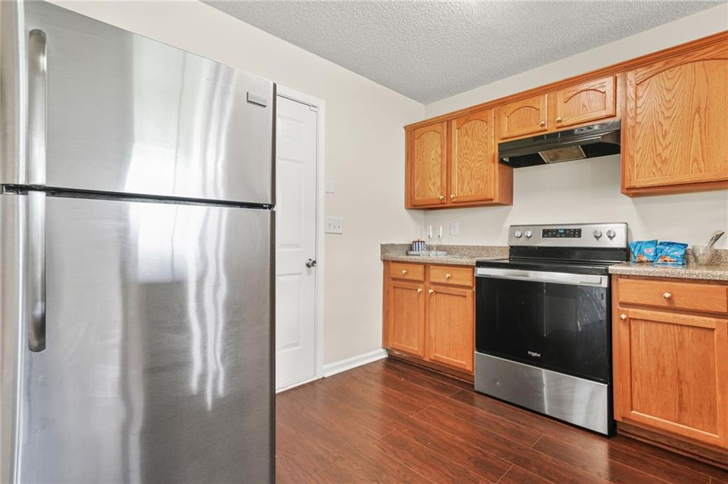 7104 Georges Way Morrow, GA 30260 - Photo 17 of 39 a kitchen with stainless steel appliances granite countertop a refrigerator a stove a sink and a microwave