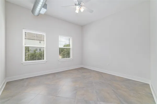 an empty room with a ceiling fan and a window