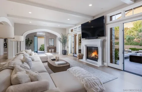 a living room with furniture fireplace and a large window