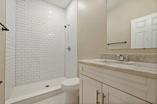 a bathroom with a granite countertop sink a toilet and shower