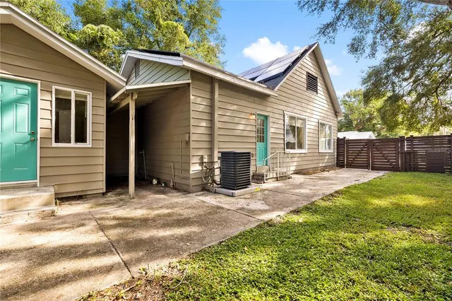 a view of a house with backyard and a tree