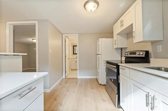 a kitchen with a refrigerator stove and white cabinets