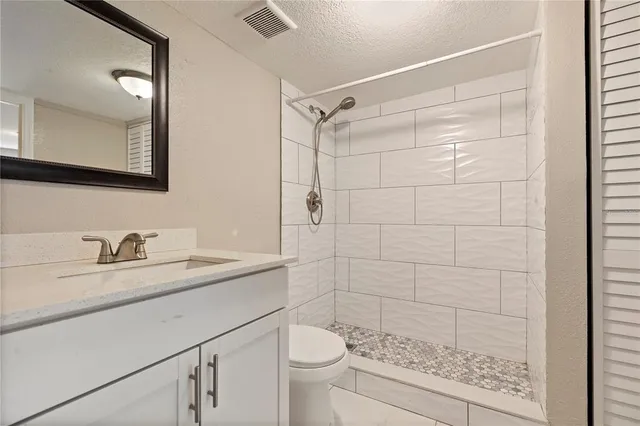 a bathroom with a granite countertop sink toilet and shower