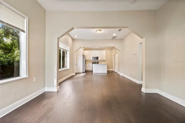 a view of a hallway with wooden floor and a living room