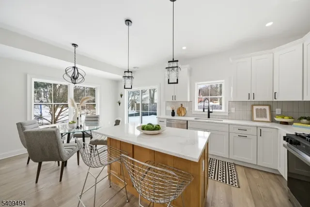 a kitchen with stainless steel appliances kitchen island granite countertop a stove a sink and a wooden floors