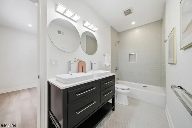 a bathroom with a sink a toilet and a mirror