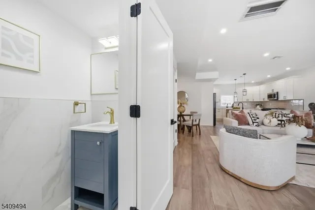 a living room with furniture a wooden floor and a sink
