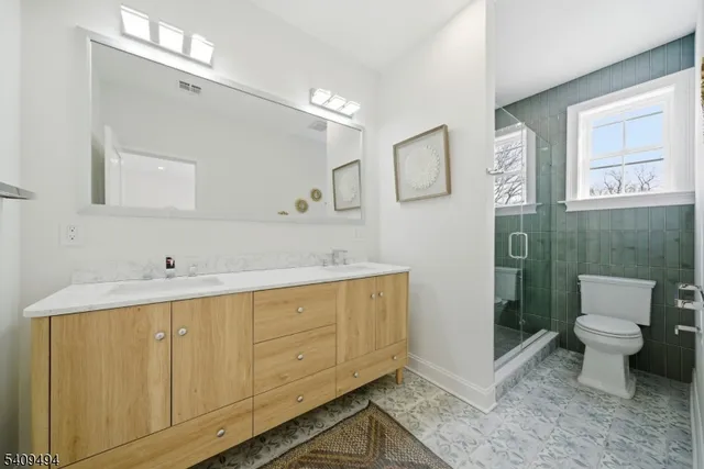 a bathroom with a sink mirror vanity and toilet