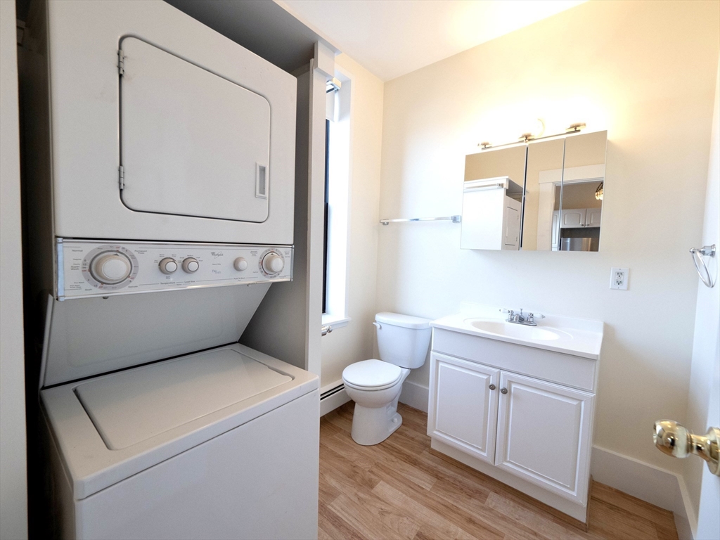 27 Fort Avenue, Unit 2 Boston, MA 02119 - Photo 6 of 7 a bathroom with a toilet sink and mirror