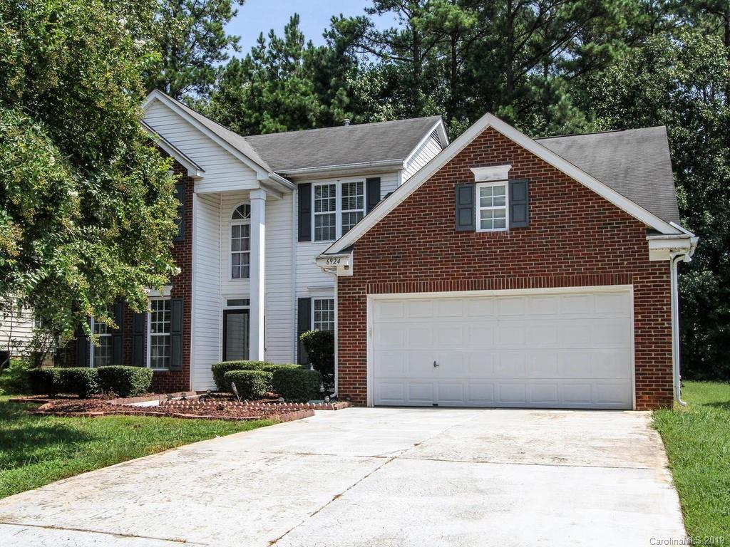 6924 Reedy Creek Road Charlotte, NC 28215 - Photo 1 of 47 a view of a white house with a small yard and large trees