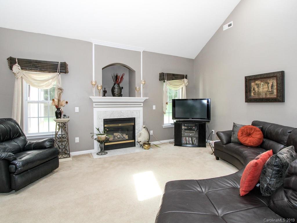 6924 Reedy Creek Road Charlotte, NC 28215 - Photo 12 of 47 a living room with furniture a flat screen tv and a fireplace