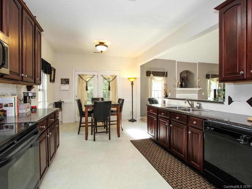 6924 Reedy Creek Road Charlotte, NC 28215 - Photo 14 of 47 a kitchen with granite countertop a sink stove and cabinets