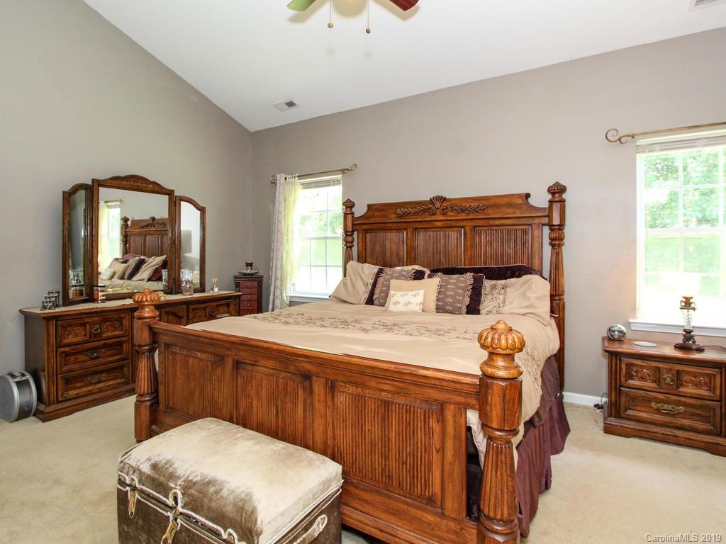 6924 Reedy Creek Road Charlotte, NC 28215 - Photo 21 of 47 a bedroom with a bed and a mirror on dresser