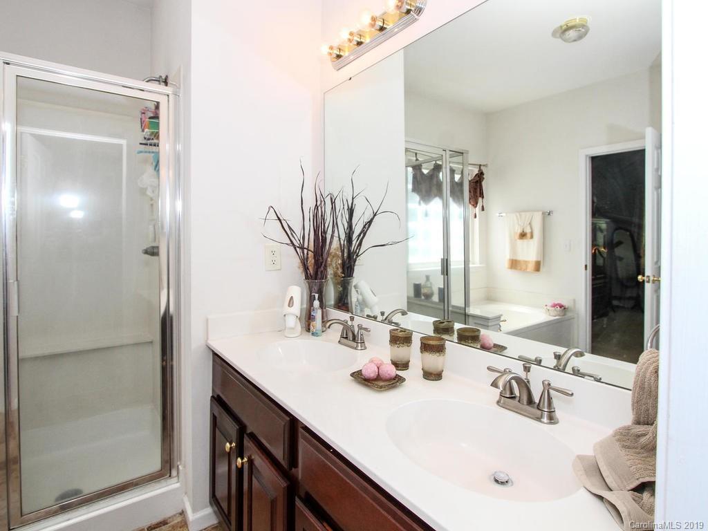 6924 Reedy Creek Road Charlotte, NC 28215 - Photo 24 of 47 a bathroom with a double vanity sink a mirror and shower