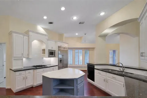 a large kitchen with lots of counter space and wooden floor