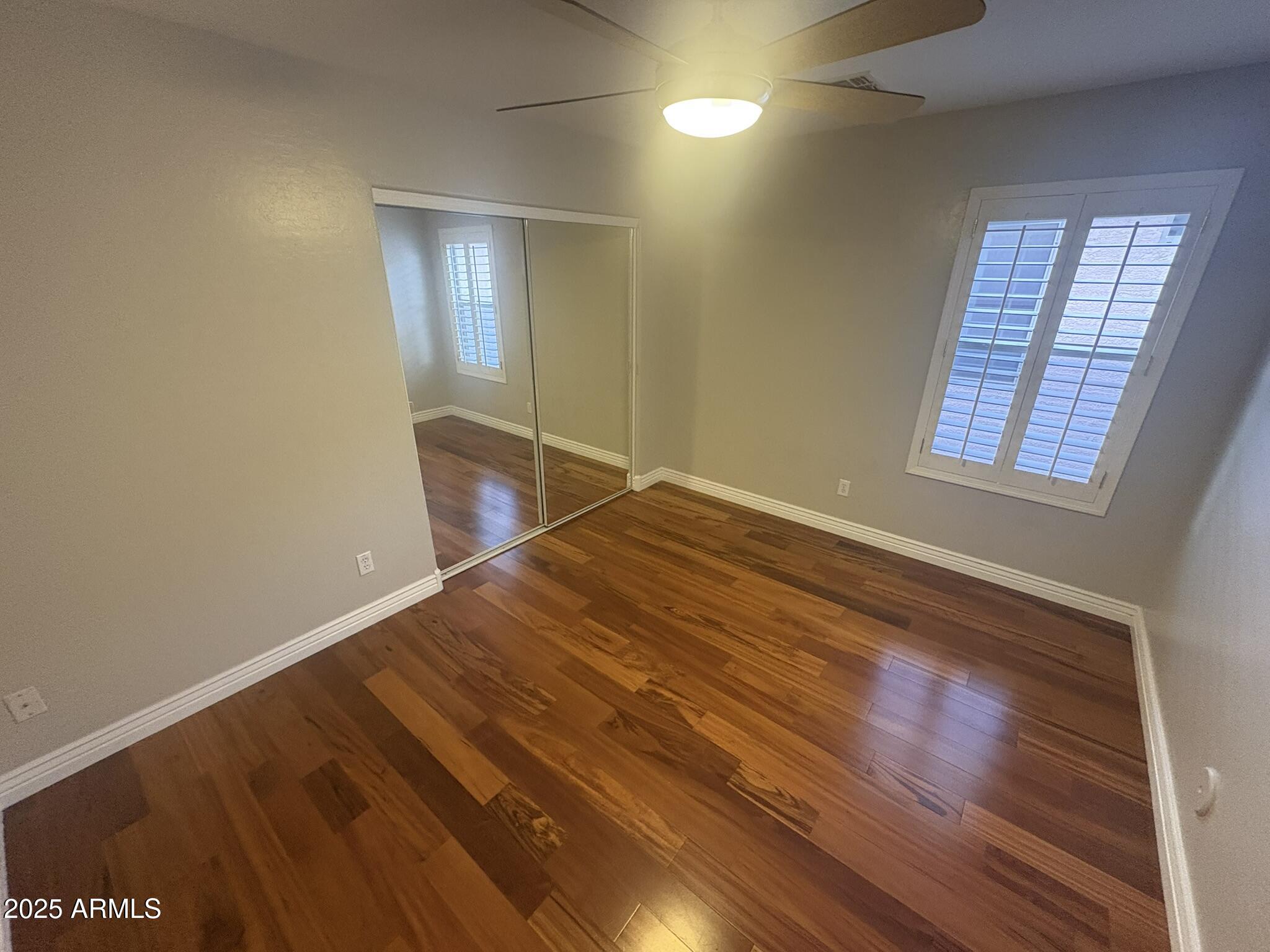 17633 North 41st Street Phoenix, AZ 85032 - Photo 15 of 24 an empty room with wooden floor and windows