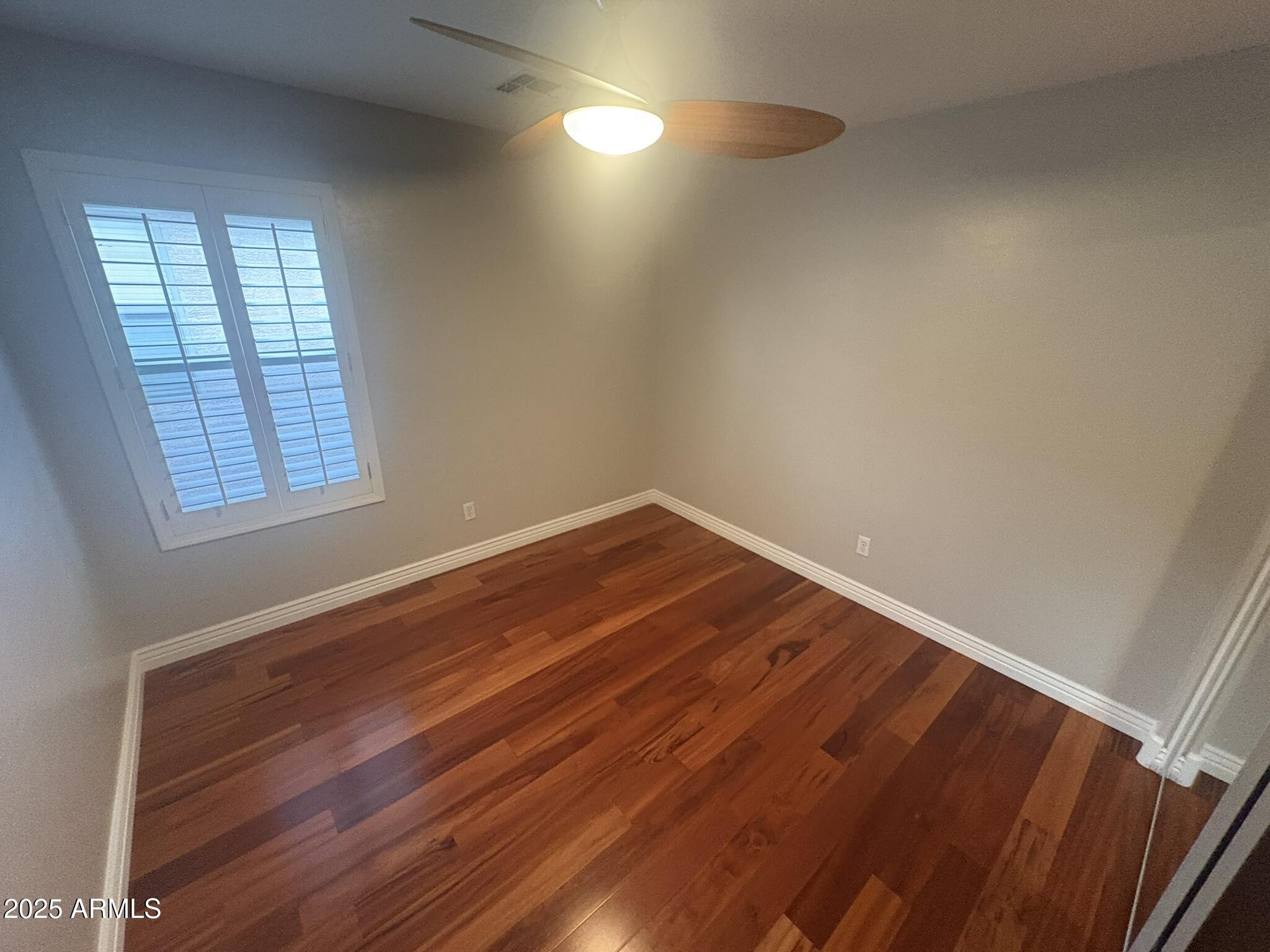 17633 North 41st Street Phoenix, AZ 85032 - Photo 17 of 24 an empty room with wooden floor and windows