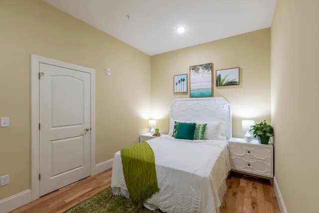 a bedroom with a bed and wooden floor