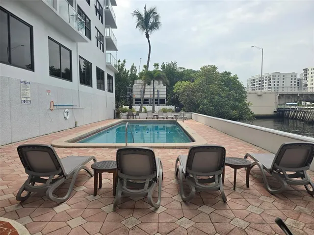 a roof deck with table and chairs and potted plants